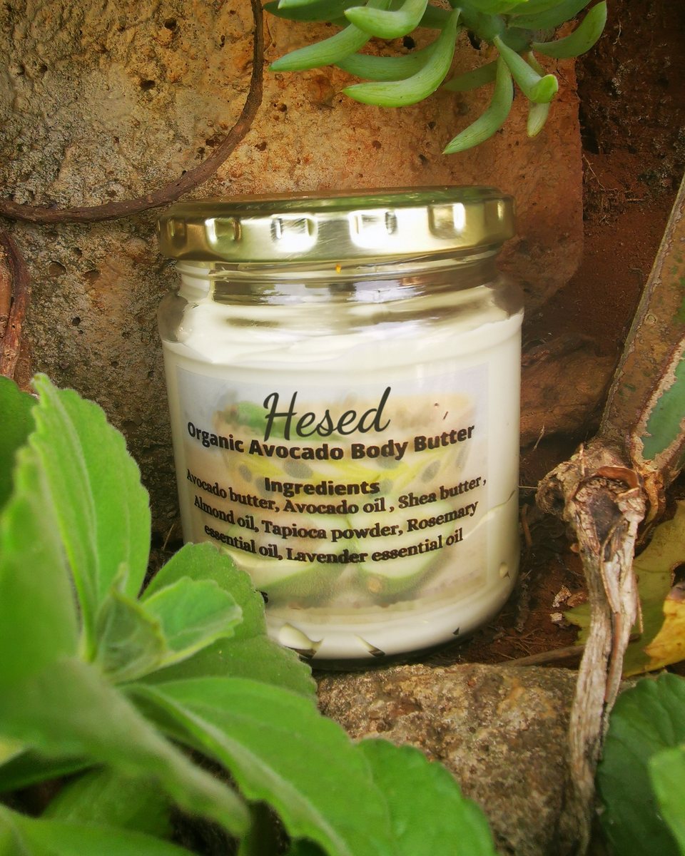 Jar of Organic Avocado Body Butter among green leaves